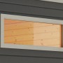 Rechteckiges Karibu Saunafenster mit Klarglas und weißem Rahmen in einer dunklen Holzwand.