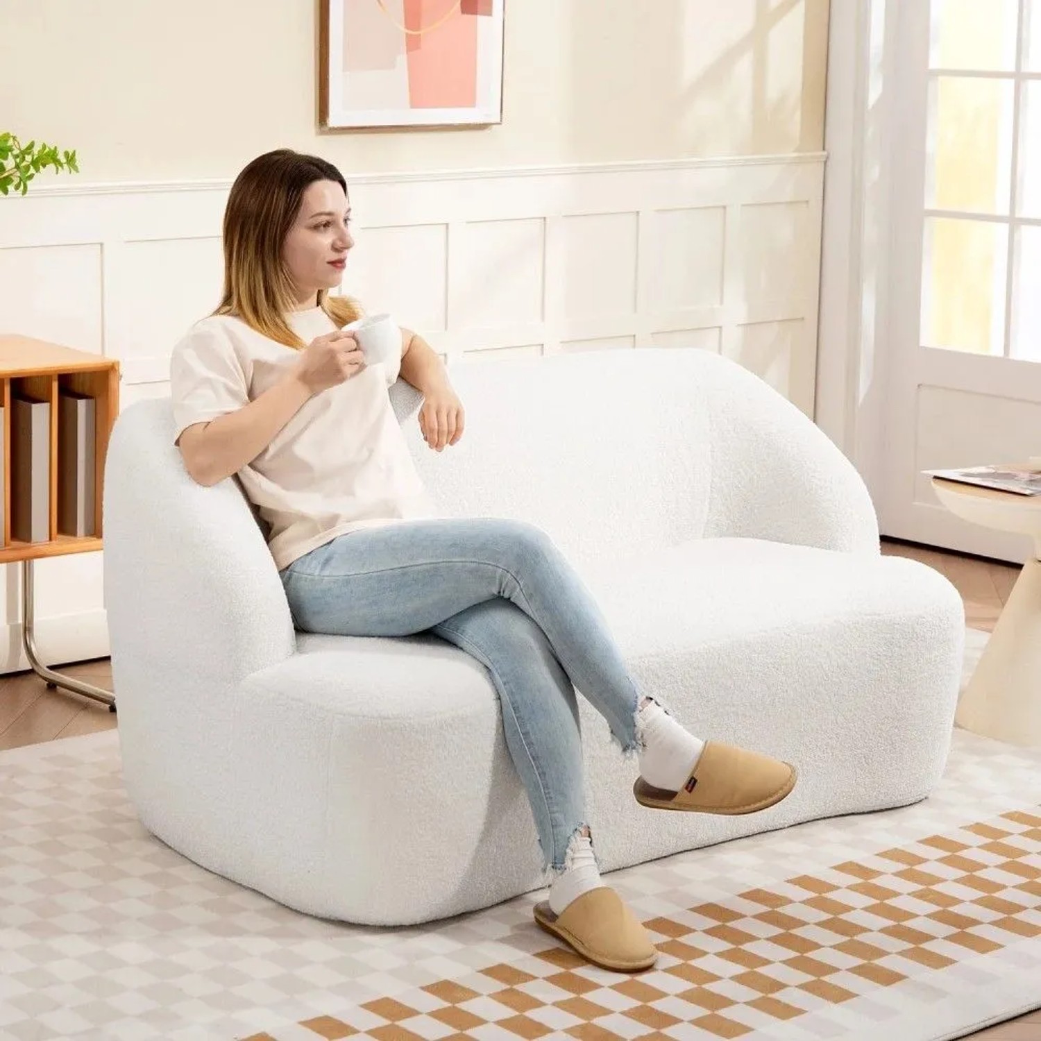 Cremeweißes HOMCOM 2-Sitzer Sofa mit geschwungenem Design im Wohnzimmer. Frau entspannt auf der gemütlichen Couch.