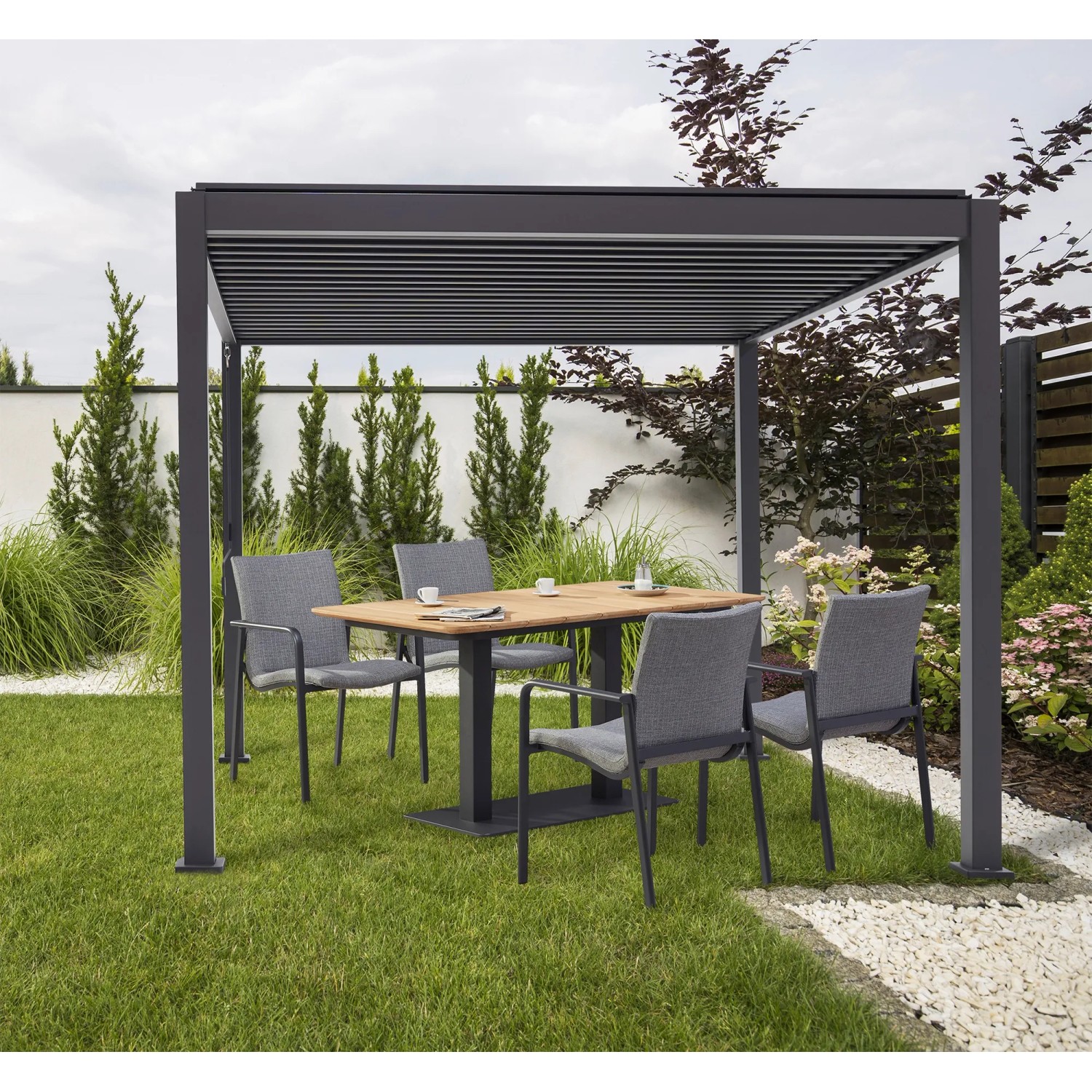 Best Terrassenüberdachung Cadiz mit Lamellendach und Gartenmöbeln im Garten.