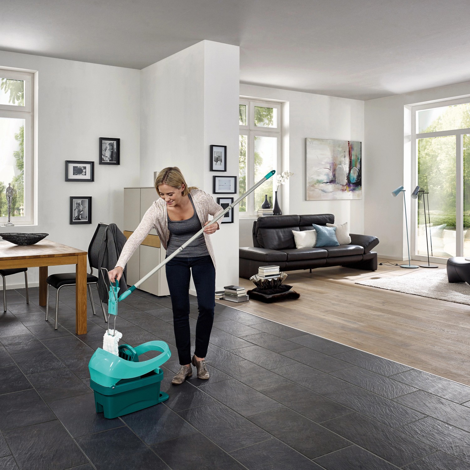 Frau benutzt Leifheit Bodenwischer mit Wischtuchpresse im Wohnzimmer.