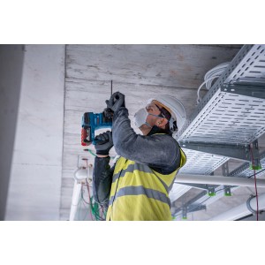 Handwerker bohrt mit dem Bosch Professional Akku-Bohrhammer GBH 18V-22 in eine Decke.