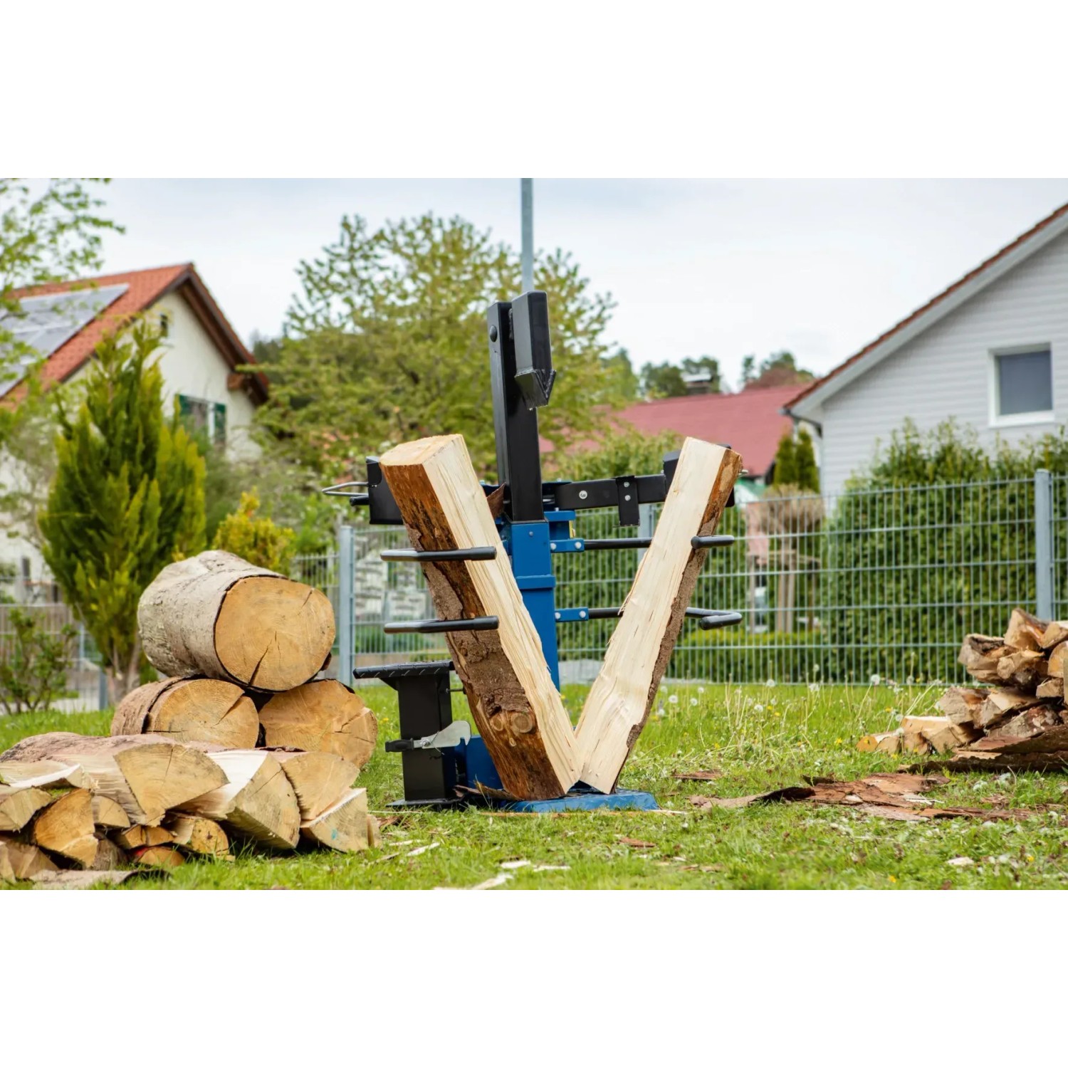 Scheppach Holzspalter Compact 8 t bei der Arbeit: Holz wird gespalten. Holzstapel im Hintergrund.