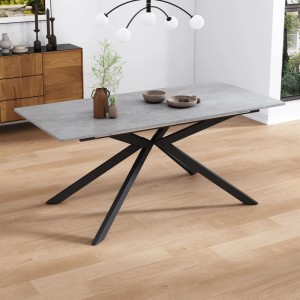 Grauer, erweiterbarer Esstisch mit moderner Betonoptik und schwarzem Metall-Kreuzfußgestell im Wohnzimmer.