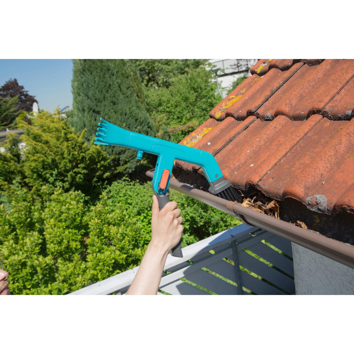 Gardena combisystem Dachrinnenreiniger im Einsatz: Dachrinnen säubern mit Bürste und Schaber.