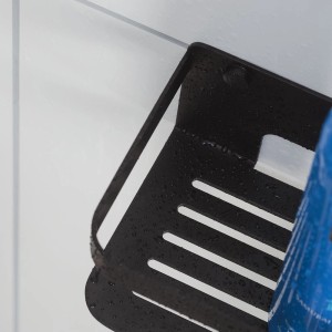 Schwarzer Tiger Duschkorb Caddy (24 cm) an weißer Wand mit Pflegeprodukt.