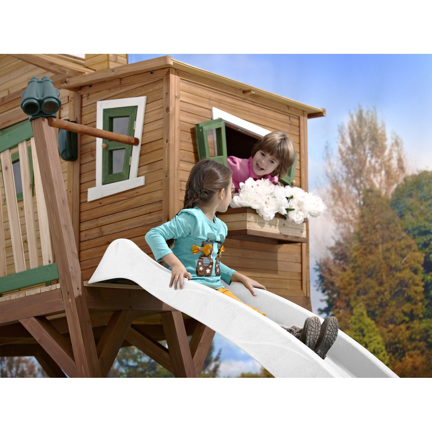 Axi Max Spielhaus mit Rutsche: Holzhaus in Braun-Grün mit spielenden Kindern.