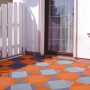 Terracottafarbene Kunststoff-Klickfliesen (6 Stk.) von Florco auf einer Terrasse verlegt.