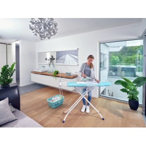 Frau bügelt Wäsche auf dem Leifheit AirBoard Compact M Plus Bügeltisch mit Bügeleisen.