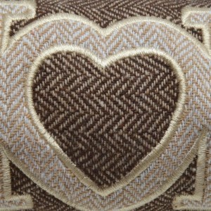 Detailaufnahme: Brauner Beautissu Tuuli Zugluftstopper mit Herzapplikation.