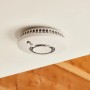 Weißer, kabelloser Yale Rauchsensor Smart Alarm an der Decke montiert.