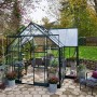 Halls Gewächshaus Garden Room, 12,9 m², grüne Aluminiumkonstruktion mit Glas, im Garten.