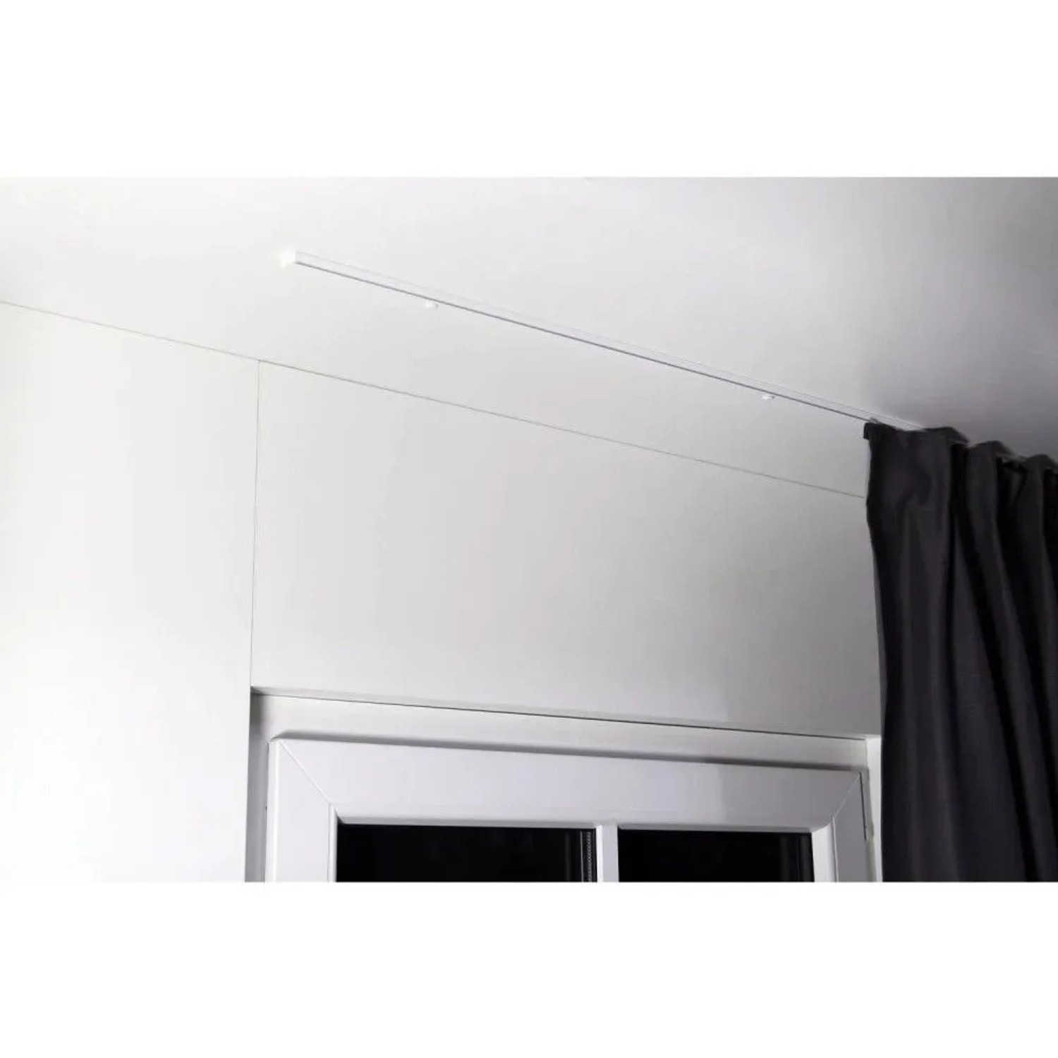 Weiße 1-Lauf Gardinenschiene zur Deckenmontage, minimalistisch, mit dunklem Vorhang am Fenster. Dekoartikel.