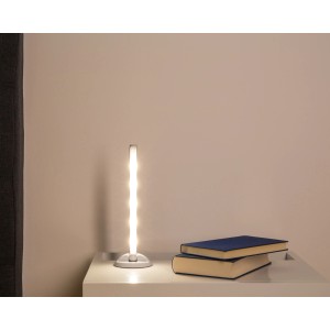 Müller-Licht LED-Unterbauleuchte Mira Dim Weiß auf Nachttisch mit Büchern.