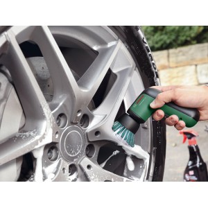 Bosch Akku-Bürste Universal Brush reinigt eine silberne Autofelge mit Schaum.
