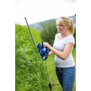 Frau schneidet Hecke mit blauer LUX Elektro-Heckenschere E-HS-500/50.