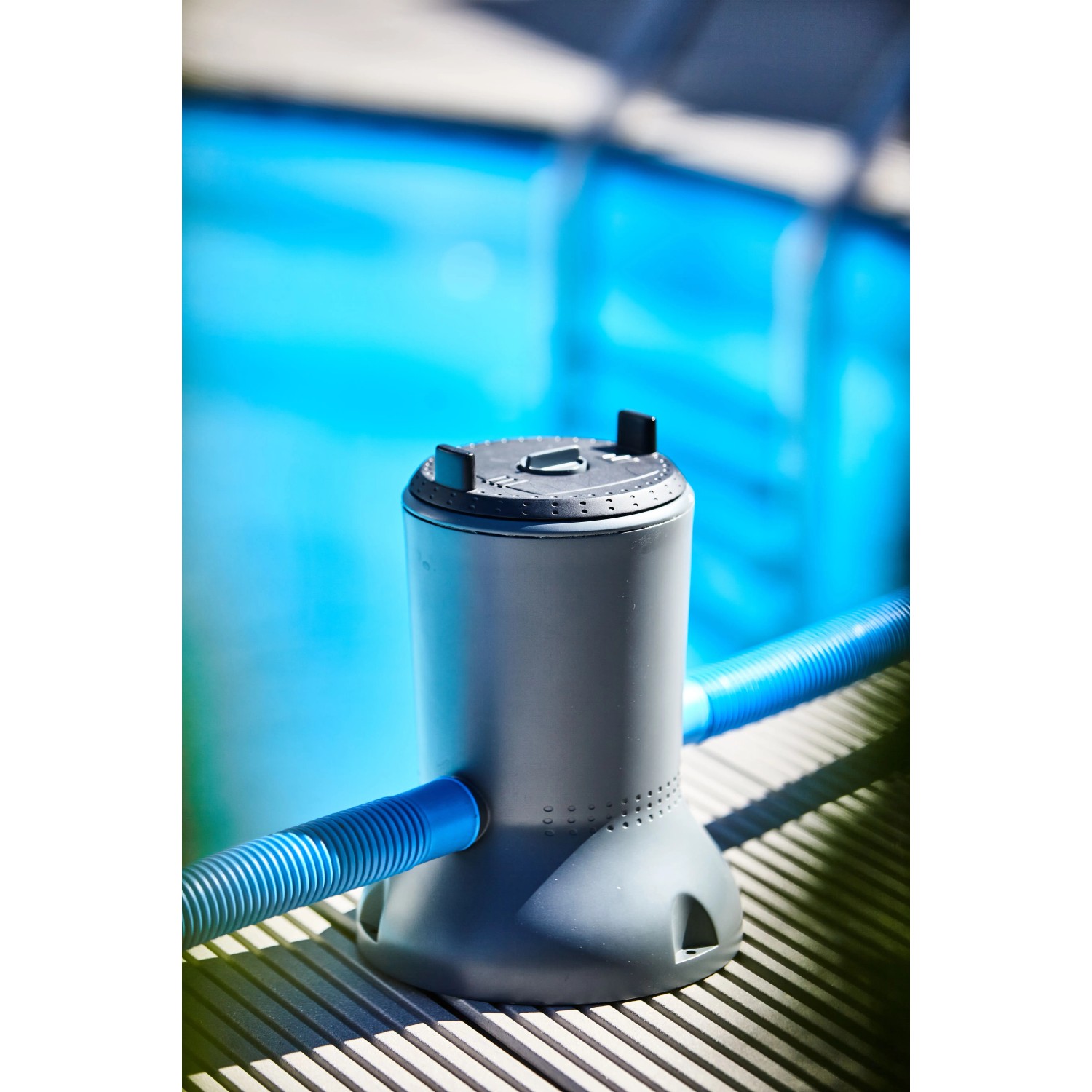Summer Fun Solar-Pool-Kartuschenfilteranlage mit Solarmodul und blauen Schläuchen vor Pool.