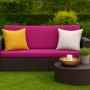 Gartensofa mit rosefarbenen Kissen und gelbem Dekokissen. Setgarden Techno Gartenkissen für Polyrattan Möbel.