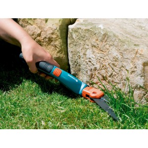 Gardena Comfort Grasschere beim Rasenkantenschneiden nahe eines Steins.