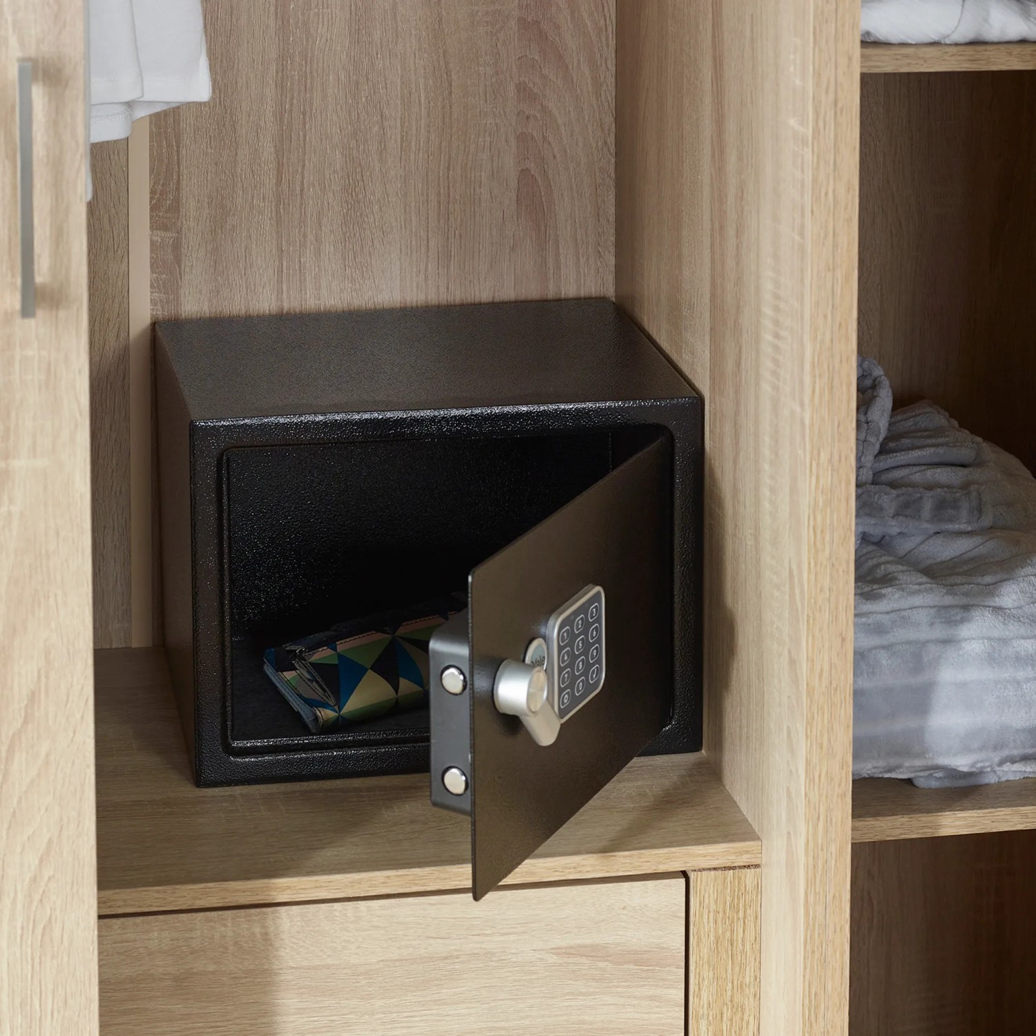 Offener, schwarzer Yale Tresor Value Safe S (8,6 l) im Holzschrank. PIN-Code-Eingabe sichtbar.