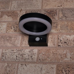 Schwarze Solar-Wandleuchte Marseille mit Sensor an einer Backsteinwand.