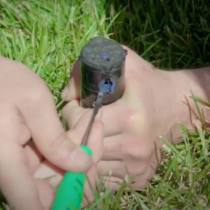 Rain Bird Rotor-Tool im Einsatz zur Einstellung eines Versenkregners im Rasen.