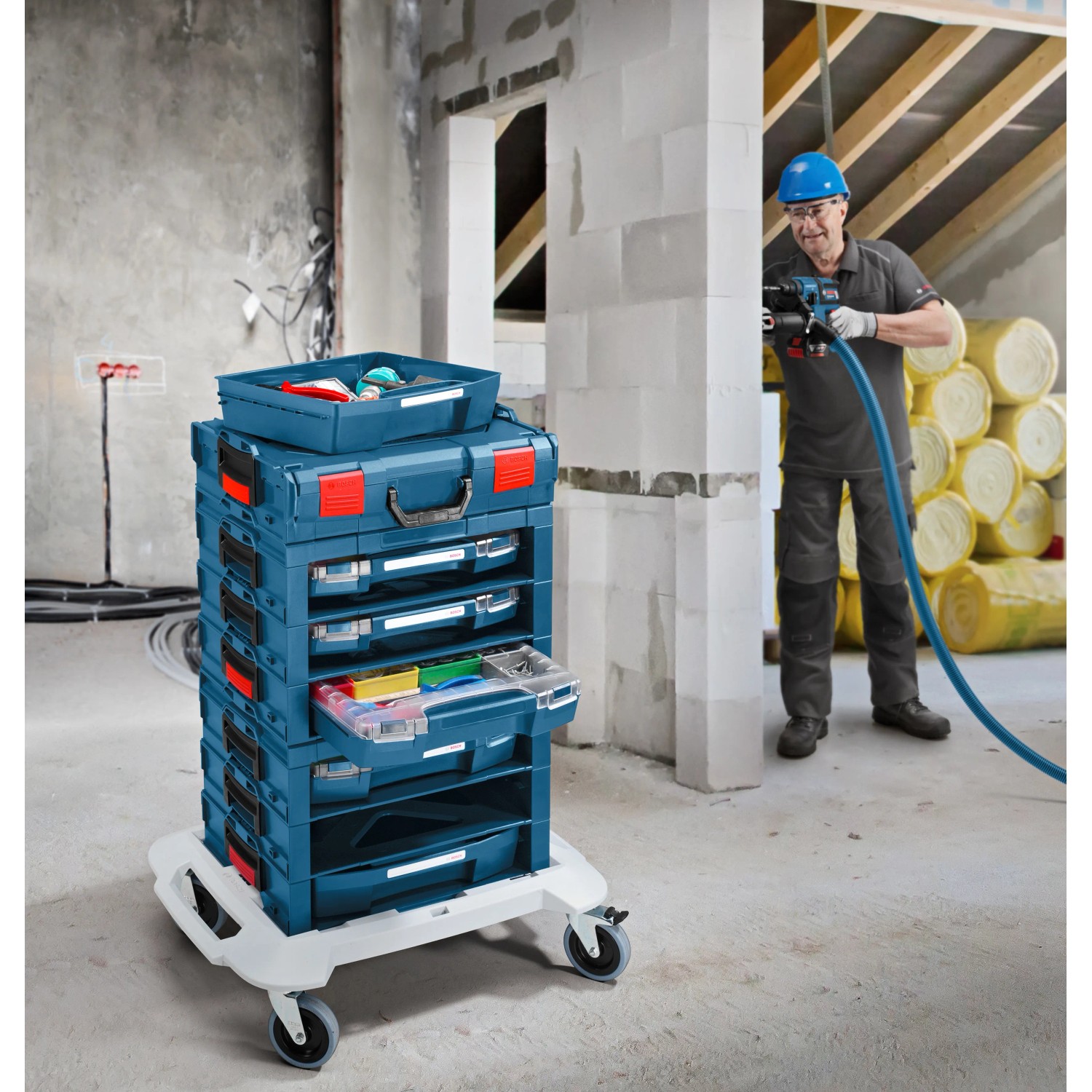 Bosch Professional L-Boxx Rollwagen mit Werkzeugkoffern auf Baustelle.
