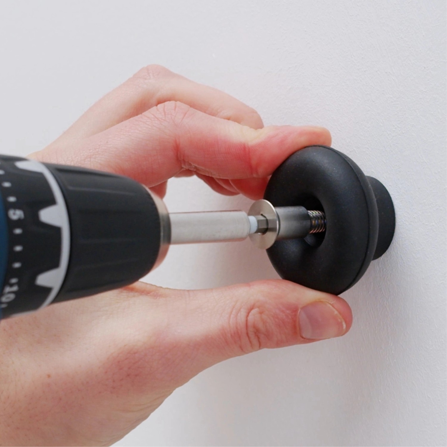 Montage des taupefarbenen Wagner Wandhakens Hooks4home Dot mit Schraubenzieher.