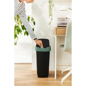 Schwarzer Rotho Swingeimer Twist 50 l in Mistletoe Green mit Person beim Müll entsorgen.