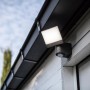 Lutec LED-Außenstrahler Sunshine mit schwenkbarem Kopf an Hauswand montiert.