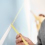 Anwendung von Tesa Malerband Professional (38mm) zum Abkleben einer Wand für präzise Farbkanten.