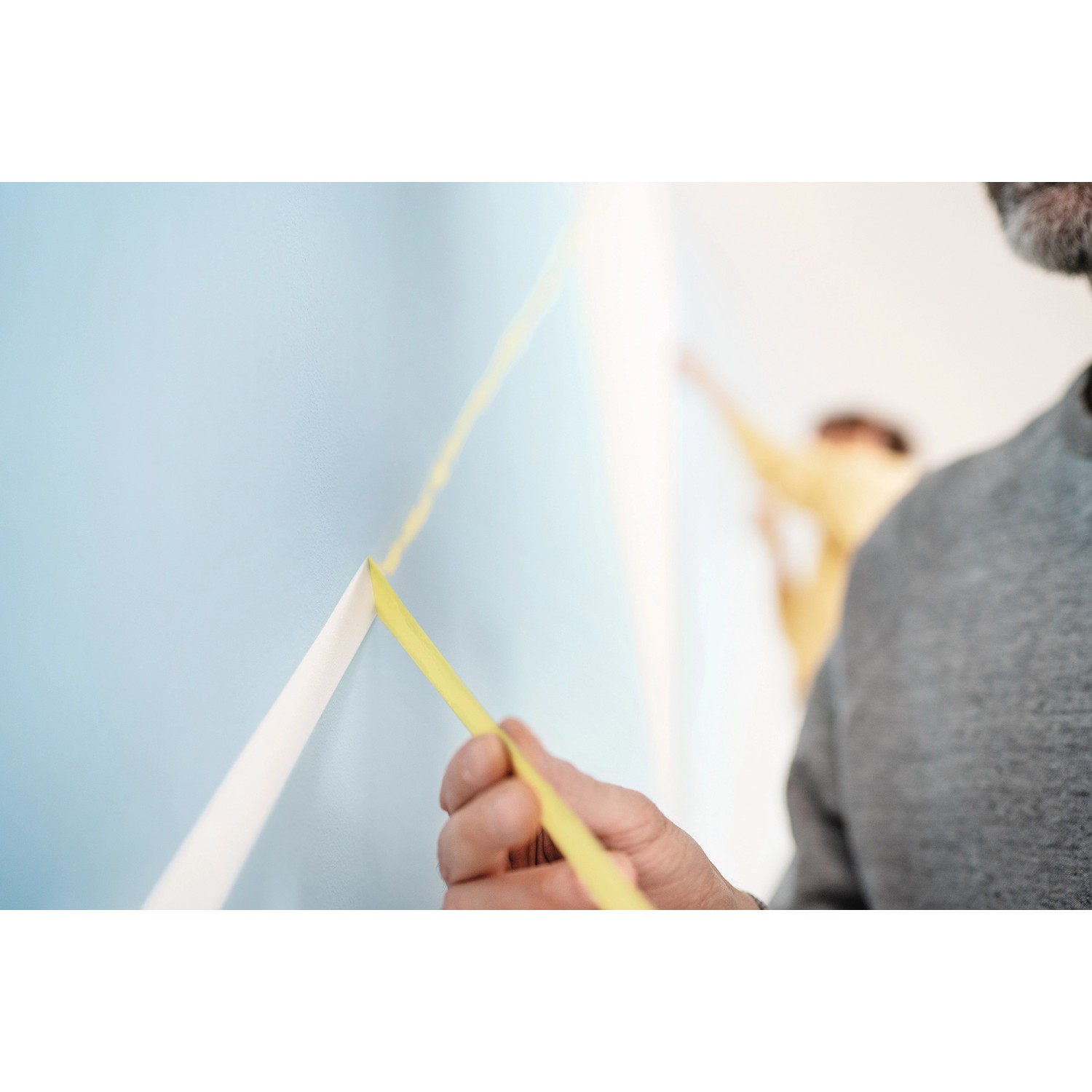 Anwendung von Tesa Malerband Professional (38mm) zum Abkleben einer Wand für präzise Farbkanten.