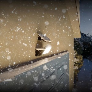 Schwarze Philips Solar-LED-Wandleuchte Fyns mit Bewegungssensor im Schnee.