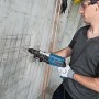Bosch Professional GBH 2-28 F Bohrhammer in Aktion beim Bohren in Betonwand.
