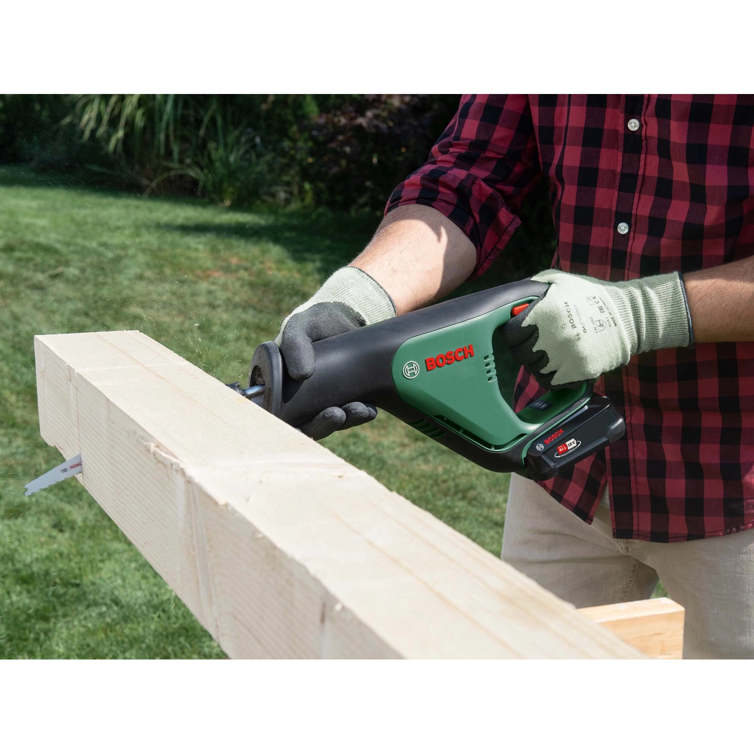 Bosch Akku-Säbelsäge AdvancedRecip 18 beim Sägen eines Holzbalkens im Garten.
