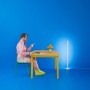 Smarte WiZ LED Stehleuchte Pole, tunable white & color, neben Schreibtisch mit Person.
