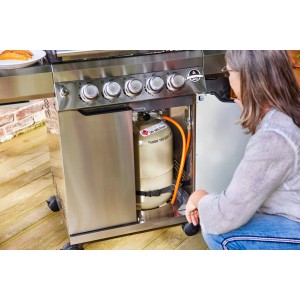 Jamestown Gasgrill Knox mit Gasflasche im Unterschrank und Frau davor.