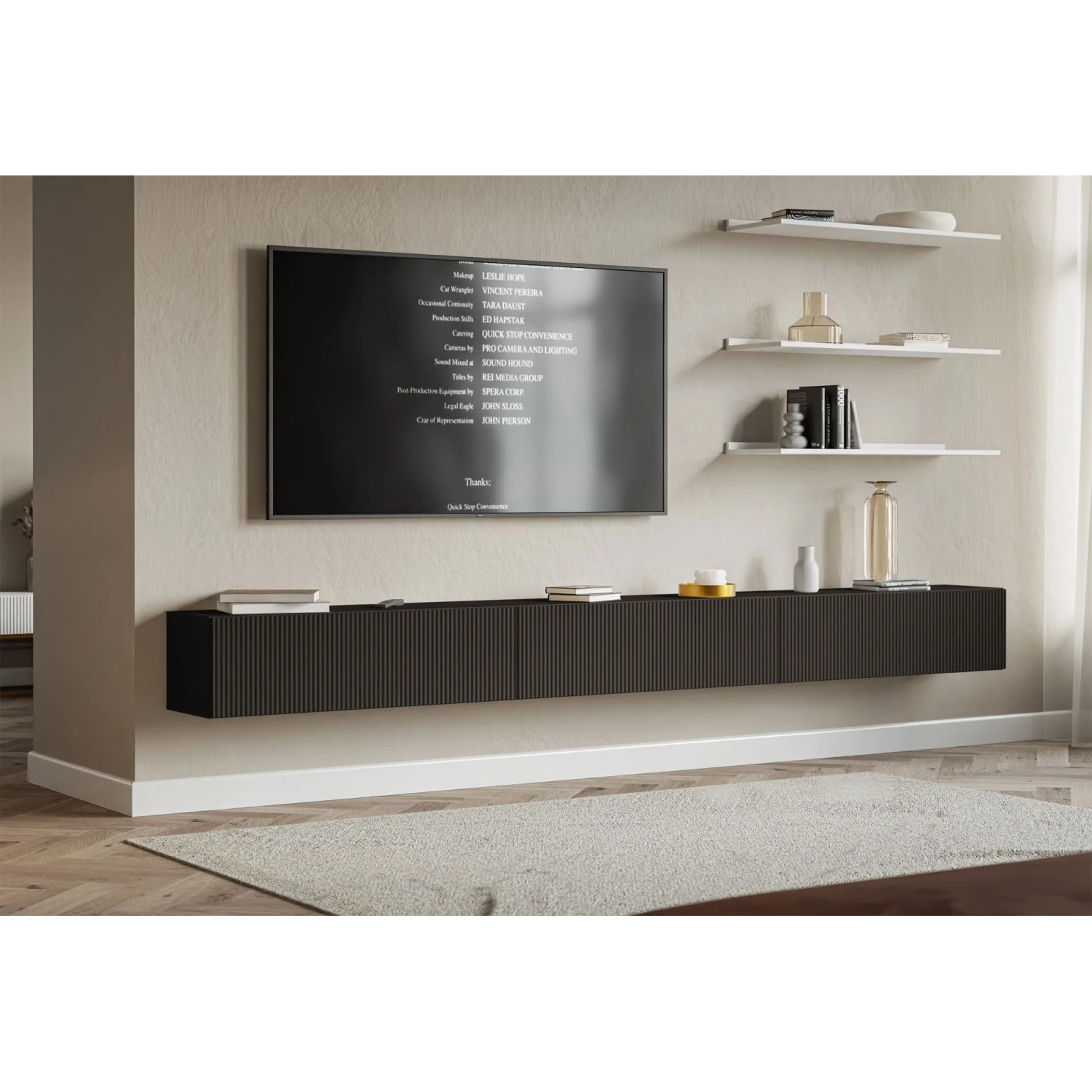 Schwarzes Selsey TV-Hängeboard Veldio mit Lamellenfront, wandhängend unter einem Fernseher im modernen Wohnzimmer.