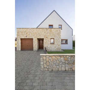 Verlegtes Premac Pflaster Graniko in Anthrazit vor einem Haus mit Steinmauer.