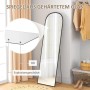 Schwarzer Ganzkörperspiegel mit Bogenform, Aluminiumrahmen und Hartglas, freistehend im Schlafzimmer.