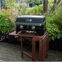 Campingaz Gas-Tischgrill Attitude 2100 LX auf Holztisch im Garten.
