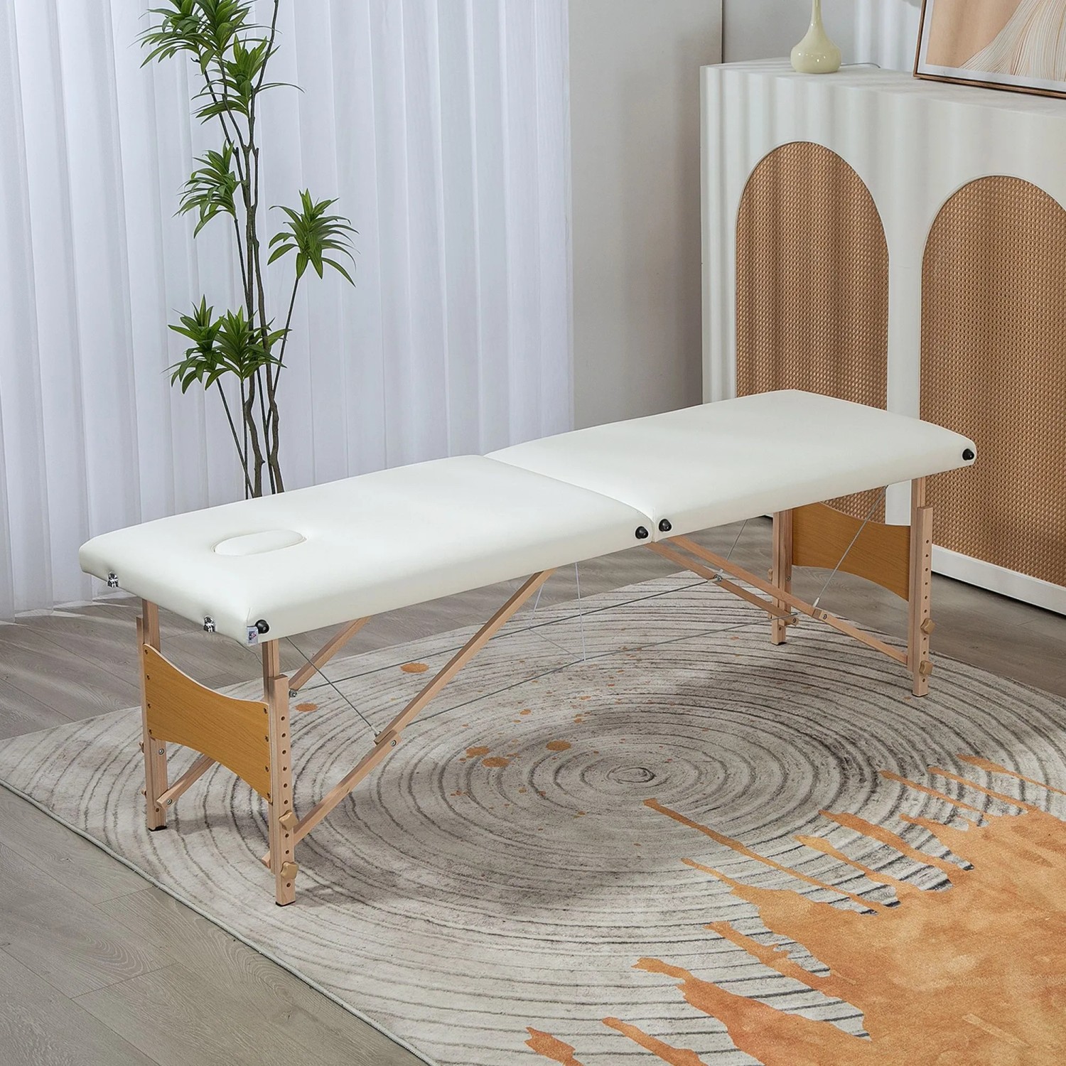 Cremeweiße, klappbare Massageliege aus Pappelholz mit verstellbarer Höhe, ideal für Wellness & Therapie.