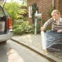 Frau verpackt Koffer mit LUX Stretchfolie für Umzug oder Transport.