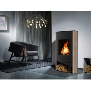 Wamsler Kaminofen N-Line Sandstein Schwarz 5 kW im Wohnraum mit Holzscheiten unter dem Ofen.