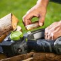 LUX-TOOLS Akku-Astsäge: Person ölt Kette der Akku-Kettensäge. Holzscheite im Hintergrund.