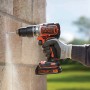 Black+Decker Akku-Schlagbohrschrauber BL188K bohrt in eine Wand, inklusive Akku und Koffer.