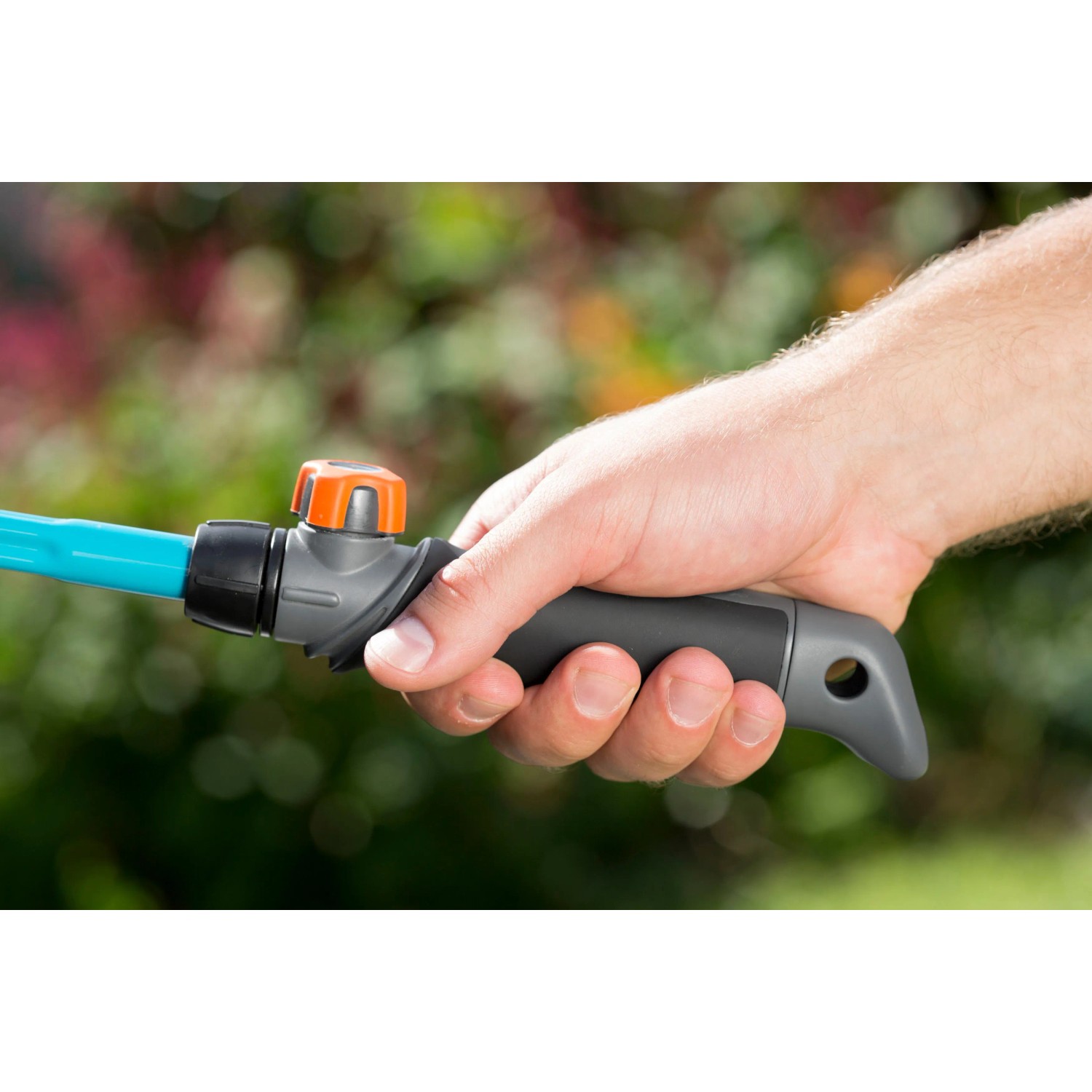 Hand hält Gardena Combisystem Griffstück für Gartengeräte.