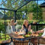 Juliana Gewächshaus Premium 13 Anthrazit mit Familie beim Essen im Garten.