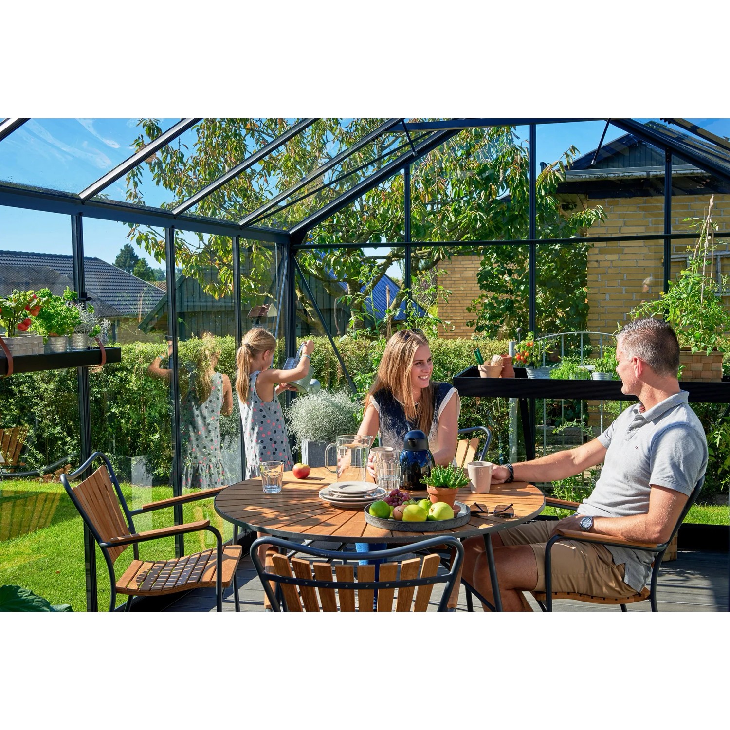 Juliana Gewächshaus Premium 13 Anthrazit mit Familie beim Essen im Garten.