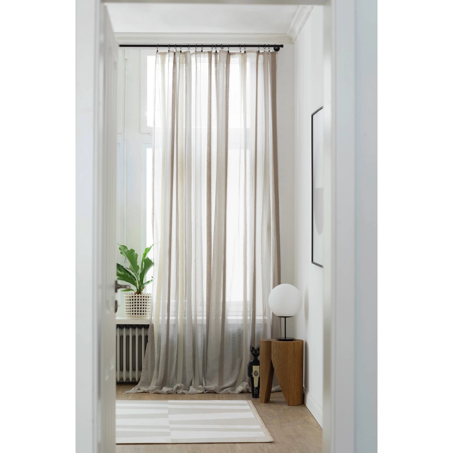 Schwarze Schöner Wohnen Gardinenstange Leon mit Vorhang im Wohnraum.