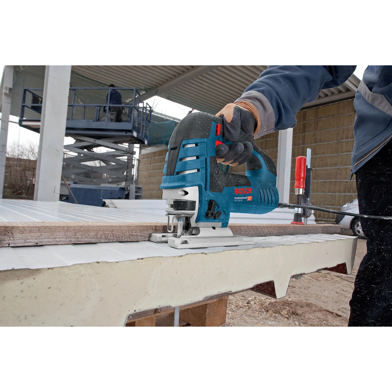 Handwerker sägt mit blauer Bosch Professional Stichsäge GST 150 CE eine dicke Platte. 780 W Leistung für präzise Kurvenschnitte.